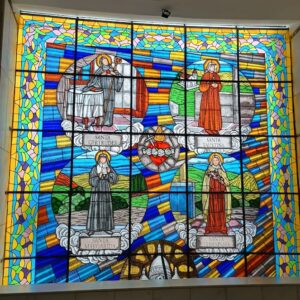 Vitral à esquerda na tríade dos vitrais frontais da Basílica